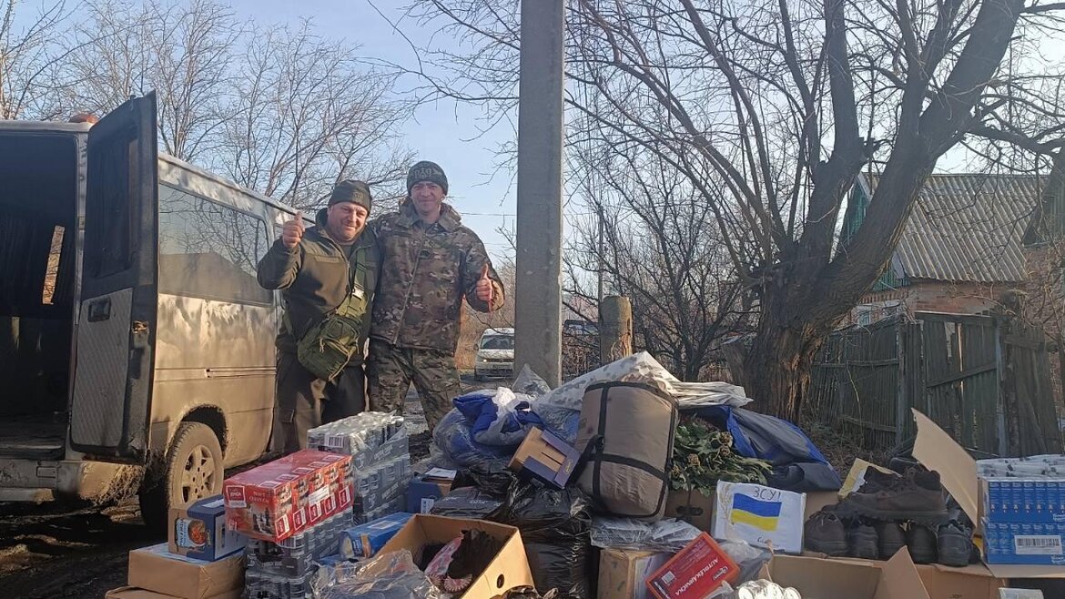 Zwei Soldaten stehen hinter einem Stapel von verschiedenen Hilfsgütern