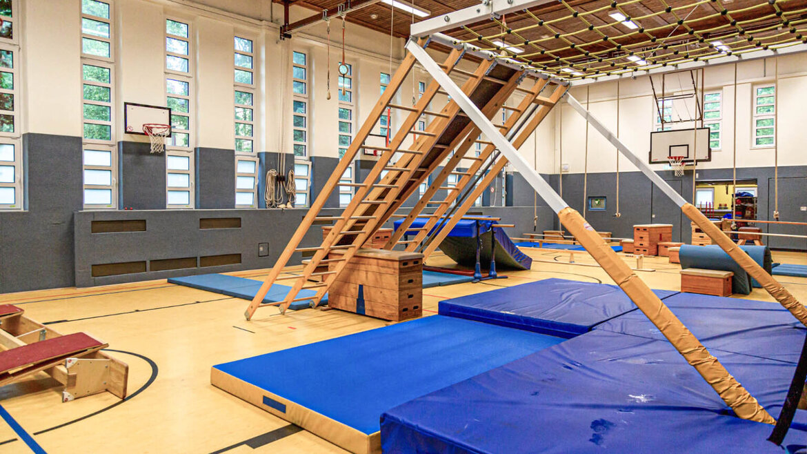 Blick in eine Sporthalle mit Kletterangeboten für Kinder
