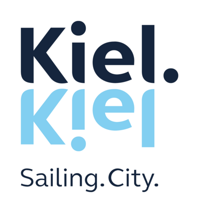Bei dem Bild handelt es sich um das Logo der Stadt Kiel. Es besteht aus dem in schwarz geschriebenen Wort "Kiel", das sich unmittelbar darunter in hellblau spiegelt. Ganz unten steht "Sailing City".