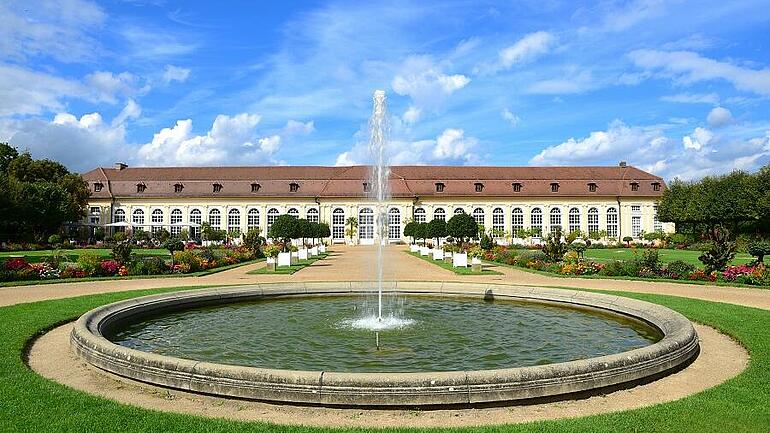 Ansbach - Die Orangerie im Ansbacher Hofgarten mit einem großen Springbrunnen im Vordergrund. 