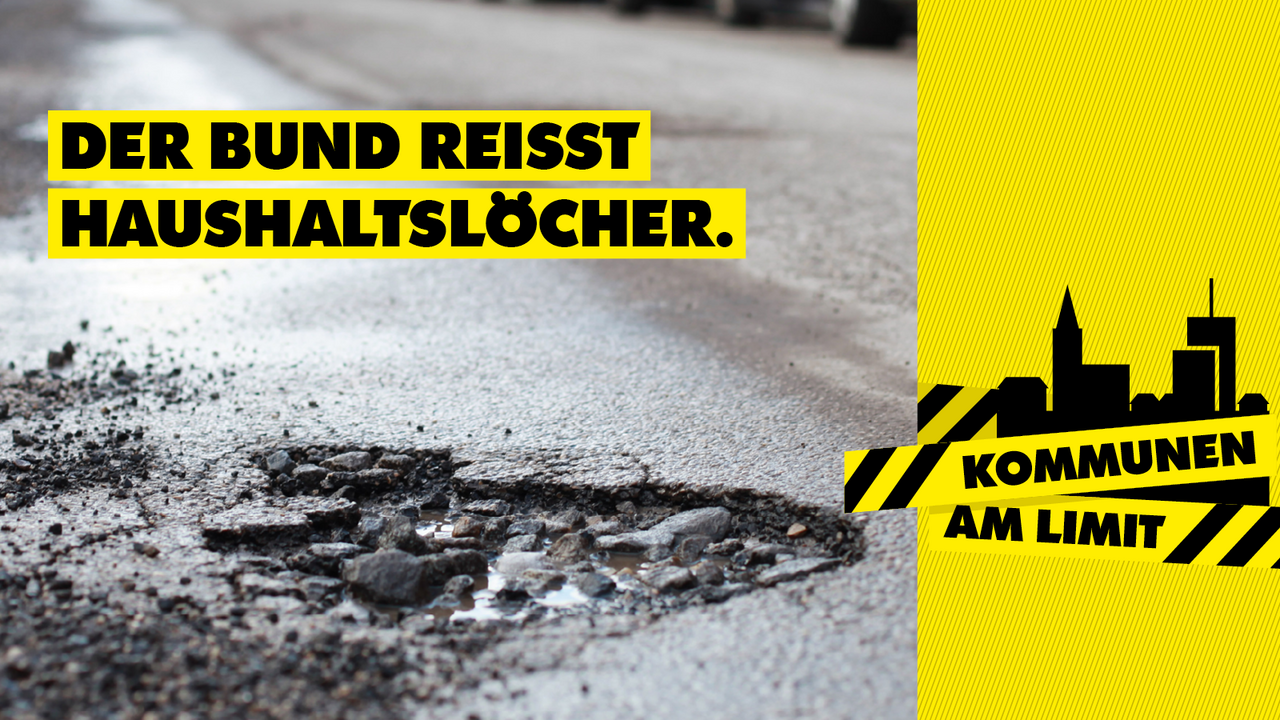 Kampagnenmotiv zum Aktionstag "Kommunen am Limit": Blick auf ein Schlagloch im Straßenbelag, darüber der Slogan "Der Bund reißt Haushaltslöcher"