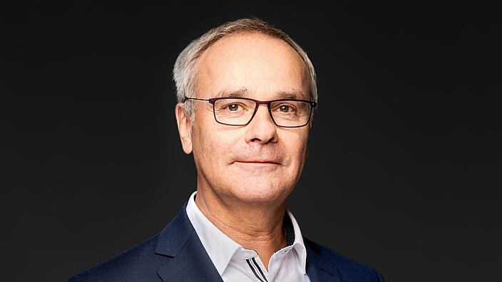 Helmut Dedy, Hauptgeschäftsführer des Deutschen Städtetages, vor dunklem Hintergrund