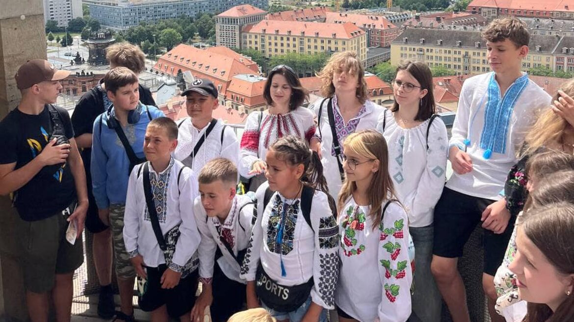 Eine Gruppe von Kindern steht vor dem Hintergrund der Dresdener Stadtkulisse