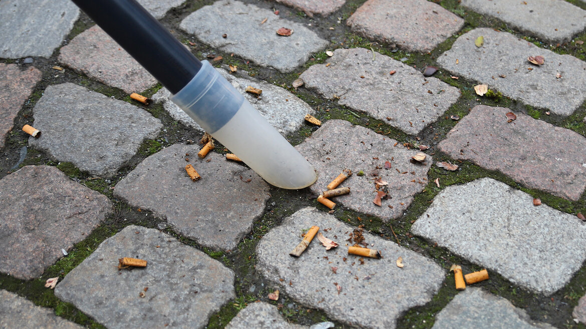 Zigarettenstummel auf Kopfsteinpflaster in der Marburger Oberstadt werden mit dem Gerät "City Bee" gereinigt.