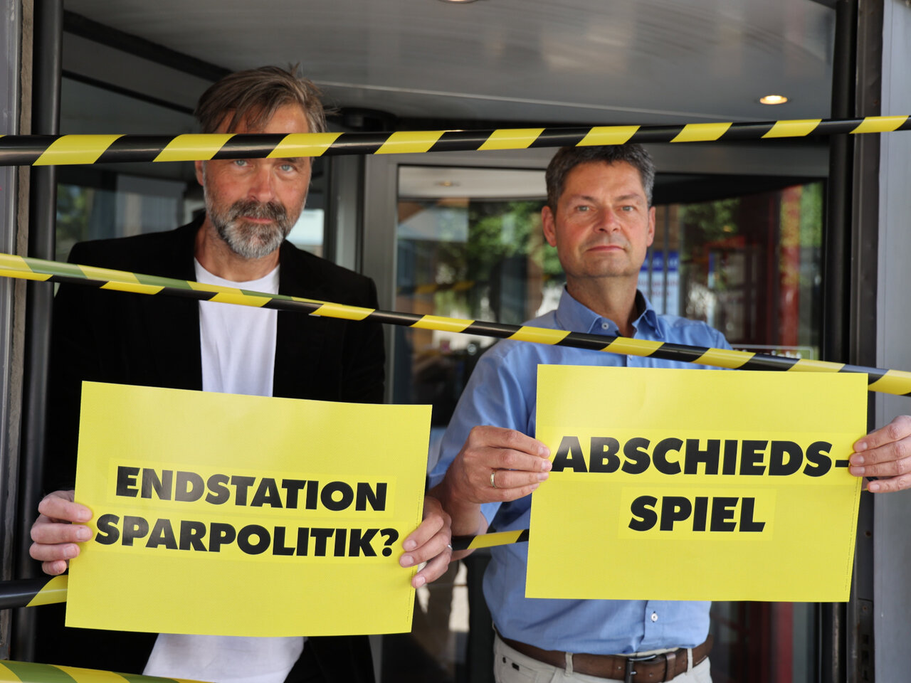 Oberbürgermeister Dr. Fabian Geyer (r.) und Bürgermeister und Kämmerer Henning Brüggemann blockieren um "Fünf vor Zwölf" die Drehtür am Rathauseingang.