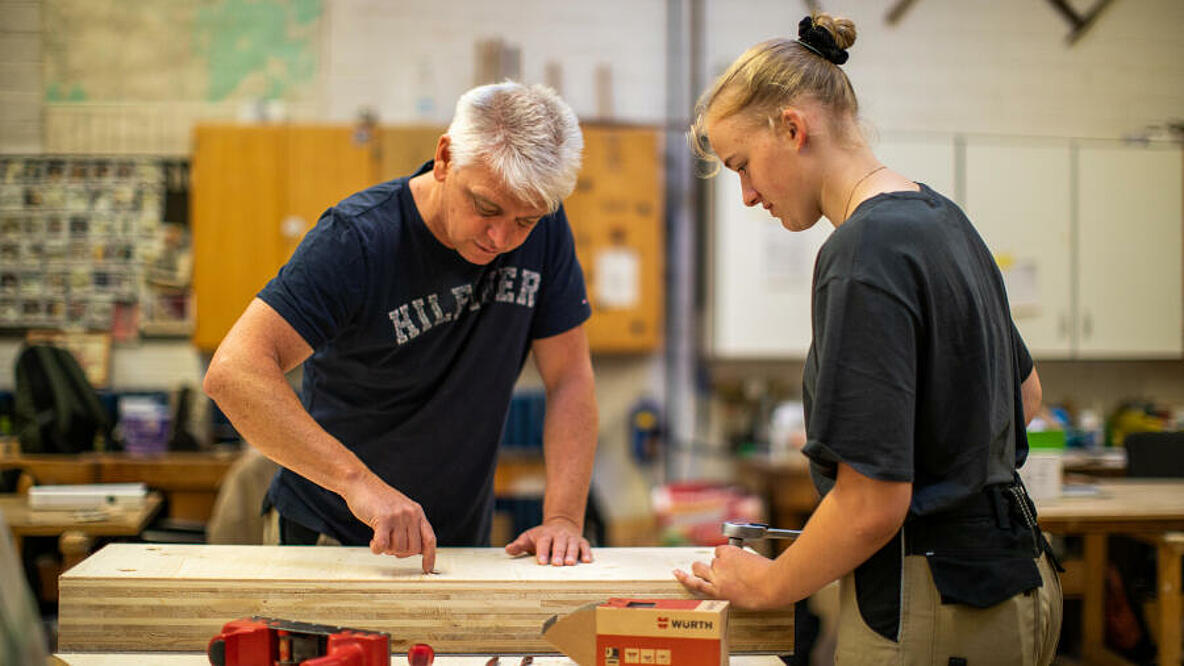 Ausbildung in der Tischlerei: Ausbilder mit Auszubildender an der Werkbank