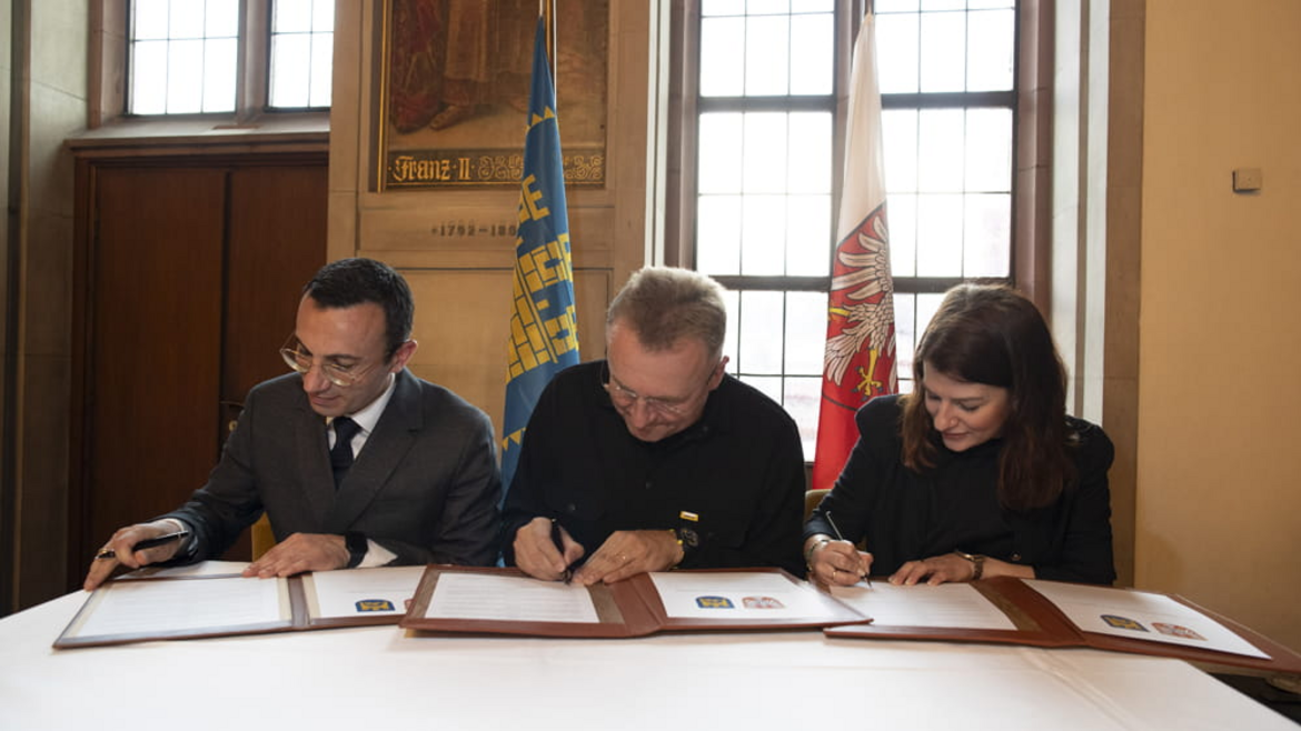 Drei Menschen unterzeichnen einen Vertrag