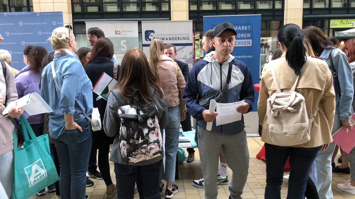 Gruppe an Menschen vor Messeaufstellern 