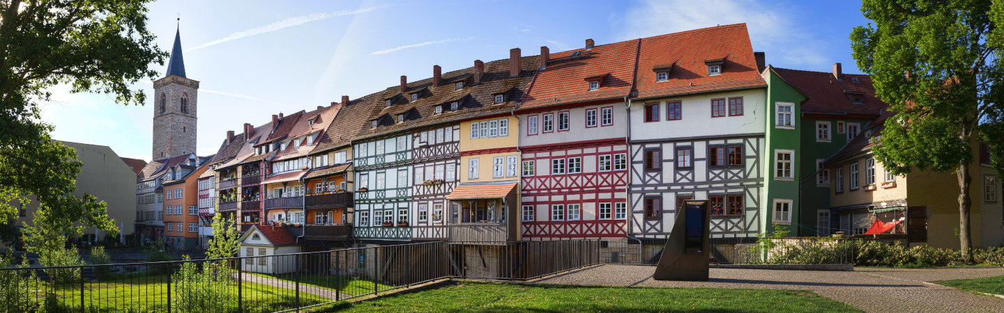 Erfurt - Die Krämerbrücke - Die längste durchgehend bebaute und bewohnte Brücke Europas ist eines der bekanntesten Wahrzeichen der Stadt. Ursprünglich aus Holz errichtet, wurde sie 1325 zur Steinbrücke mit zahlreichen Kaufmannsbuden, den "Krämern", ausgebaut. Direkt neben der Brücke wurde 2007 eine mittelalterliche Mikwe bei Grabungsarbeiten entdeckt.